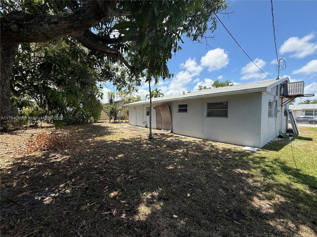 660 SW 14th Pl, Deerfield Beach, FL 33441 - back of property with stucco siding and a lawn
