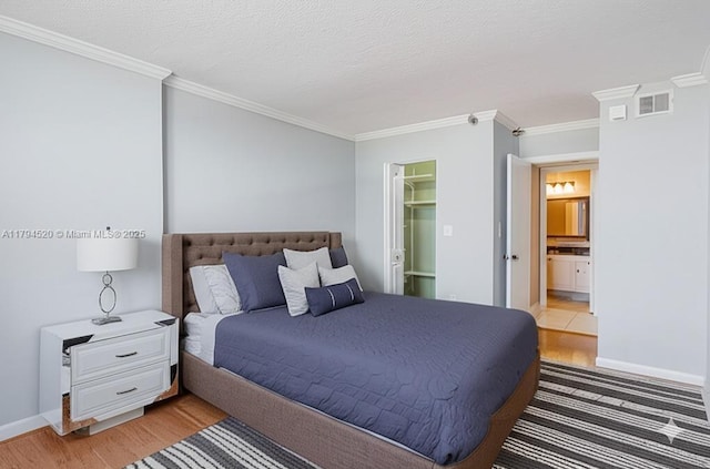 1500 N Ocean Blvd Unit 502, Pompano Beach, FL 33062 - bedroom with crown molding, light wood-style floors, a spacious closet, baseboards, and ensuite bathroom
