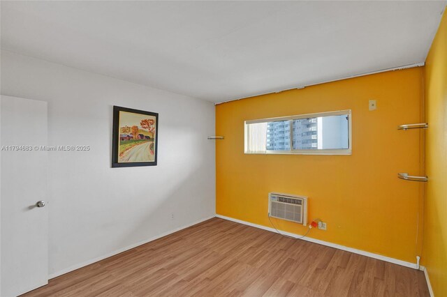 13105 Ixora Ct Unit 319, North Miami, FL 33181 - spare room featuring a wall mounted air conditioner, wood finished floors, and baseboards