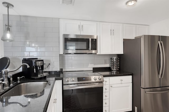 770 Claughton Island Dr Unit 1114, Miami, FL 33131 - kitchen featuring appliances with stainless steel finishes, decorative backsplash, dark stone counters, white cabinets, and pendant lighting