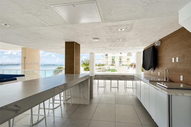 770 Claughton Island Dr Unit 1114, Miami, FL 33131 - kitchen with white cabinetry, light tile patterned floors, wood walls, modern cabinets, and open floor plan