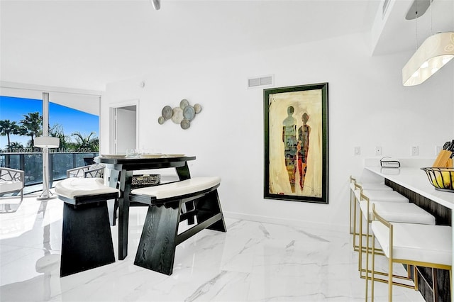 dining room featuring marble finish floor, baseboards, visible vents, and floor to ceiling windows