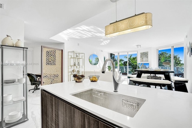488 NE 18th St Unit 208, Miami, FL 33132 - kitchen with light countertops, light marble finish flooring, dark brown cabinets, and hanging light fixtures