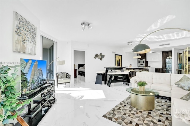 living area with visible vents and marble finish floor