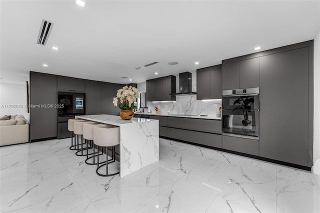 13211 SW 6th St, Miami, FL 33184 - kitchen with a breakfast bar area, wall chimney exhaust hood, visible vents, modern cabinets, and a kitchen island