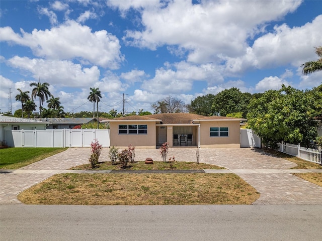 104 N 31st Ct, Hollywood, FL 33021 - view of front of home with fence, stucco siding, decorative driveway, and a front yard