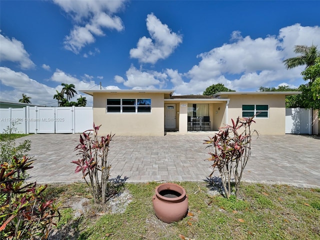 104 N 31st Ct, Hollywood, FL 33021 - prairie-style home with a patio area, stucco siding, fence, and a gate