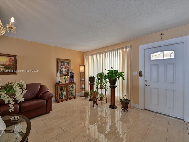 104 N 31st Ct, Hollywood, FL 33021 - foyer with a textured ceiling, baseboards, and a notable chandelier
