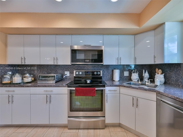 104 N 31st Ct, Hollywood, FL 33021 - kitchen with a toaster, a sink, white cabinetry, decorative backsplash, and stainless steel appliances