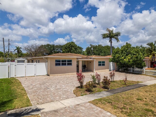 104 N 31st Ct, Hollywood, FL 33021 - single story home featuring a gate, fence, stucco siding, a front yard, and decorative driveway