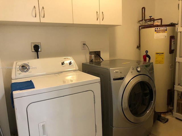 laundry room featuring cabinet space, water heater, and washing machine and clothes dryer
