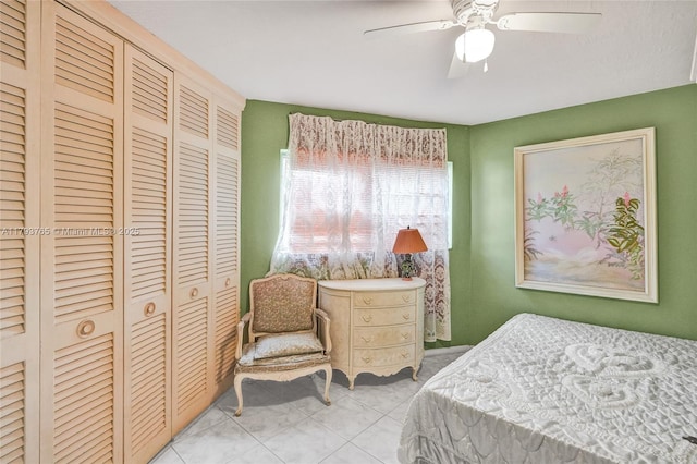 bedroom with ceiling fan, a closet, and light tile patterned floors