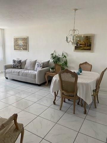dining room featuring a chandelier and marble finish floor