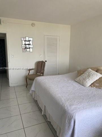 bedroom with marble finish floor and a closet