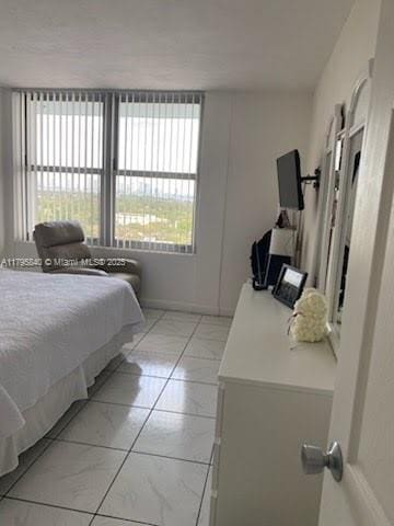 bedroom with baseboards and marble finish floor