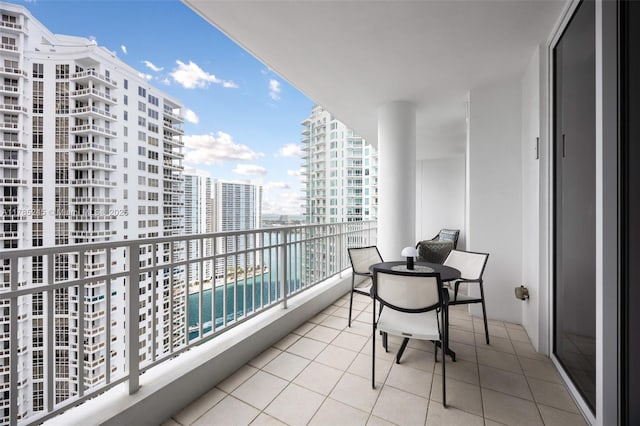 balcony with a water view and a view of city