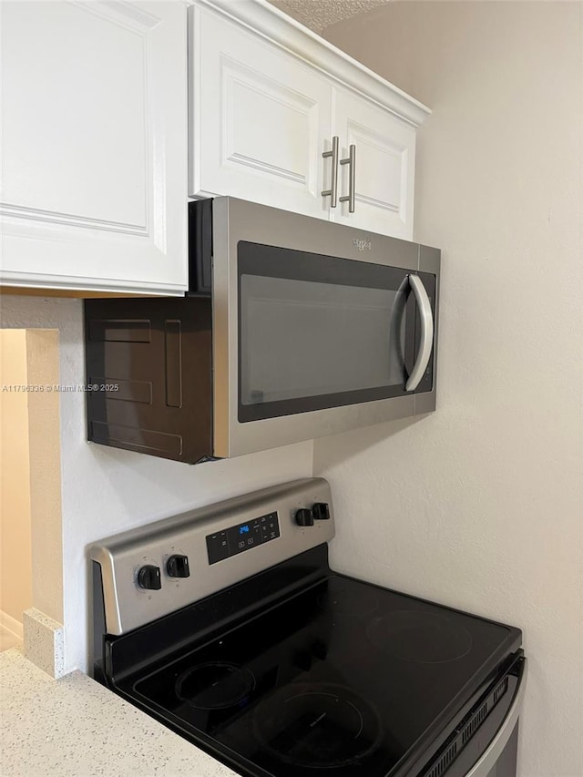 details featuring light countertops, white cabinets, and appliances with stainless steel finishes