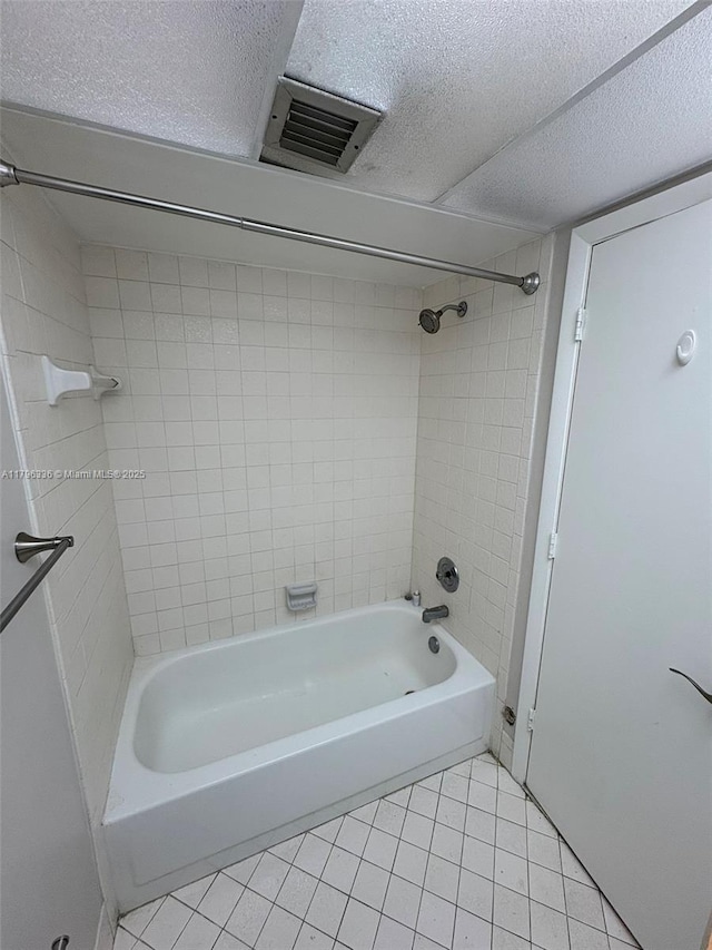 bathroom featuring a textured ceiling, visible vents, tile patterned flooring, and tub / shower combination