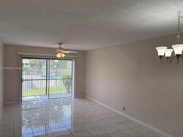 unfurnished room with a textured ceiling, ceiling fan with notable chandelier, baseboards, and light tile patterned floors