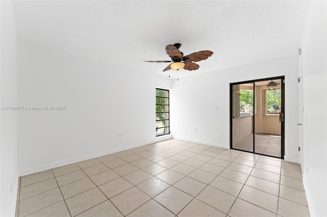 spare room with light tile patterned floors, baseboards, and ceiling fan