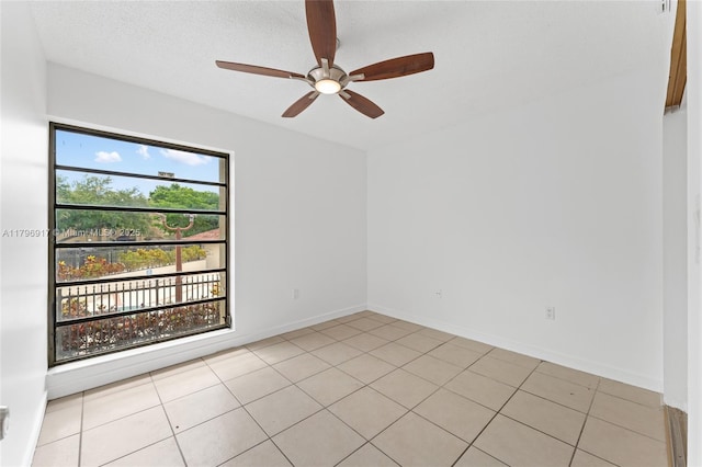 unfurnished room with ceiling fan, baseboards, and light tile patterned floors