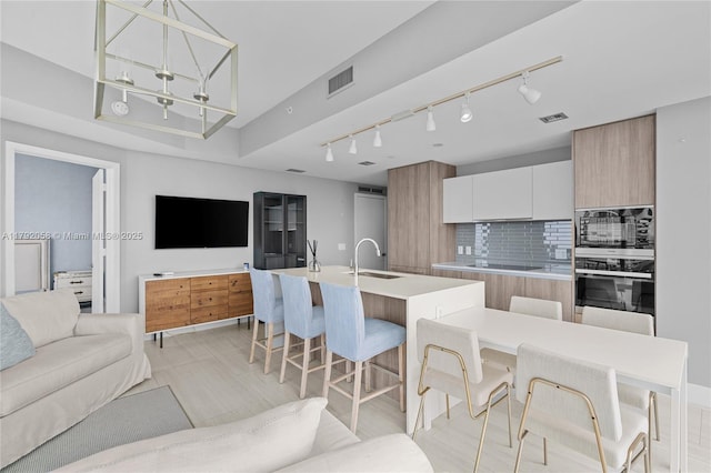kitchen featuring a large island, visible vents, modern cabinets, and open floor plan