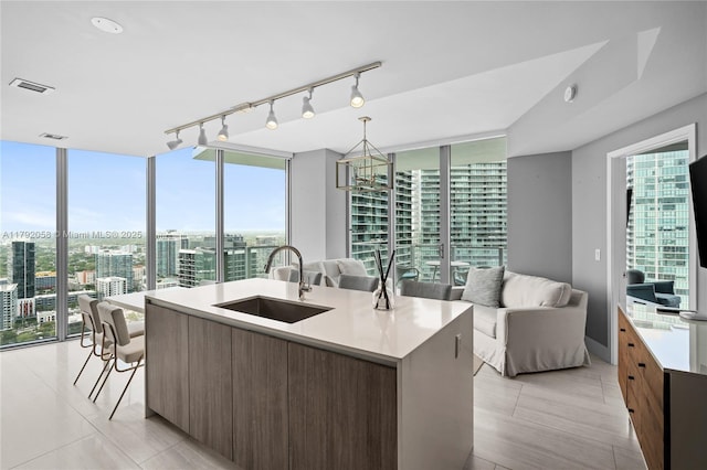 kitchen with a sink, open floor plan, light countertops, and modern cabinets