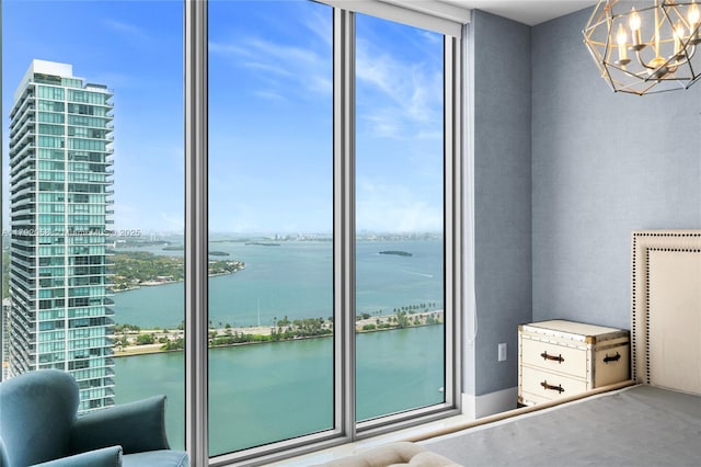interior space featuring floor to ceiling windows, a water view, and a notable chandelier