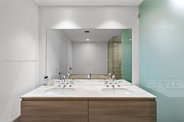 bathroom with double vanity, a washtub, a shower with shower door, and a sink