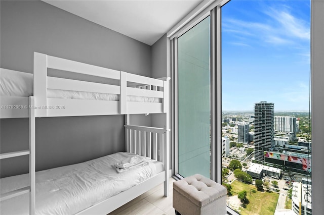 bedroom featuring a view of city and expansive windows