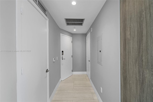 hall featuring electric panel, visible vents, baseboards, and recessed lighting
