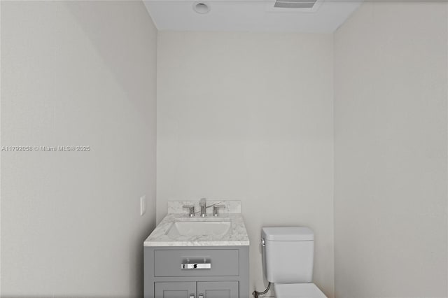 half bathroom with toilet and vanity