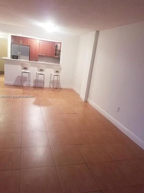 unfurnished living room with baseboards