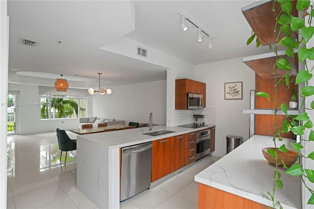 18445 NE 27th Pl, Aventura, FL 33160 - kitchen with brown cabinets, stainless steel appliances, visible vents, and a sink