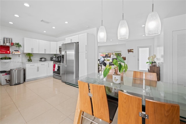 kitchen featuring light tile patterned floors, stainless steel appliances, white cabinets, backsplash, and recessed lighting
