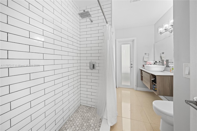 full bath featuring tile patterned floors, vanity, toilet, and tiled shower