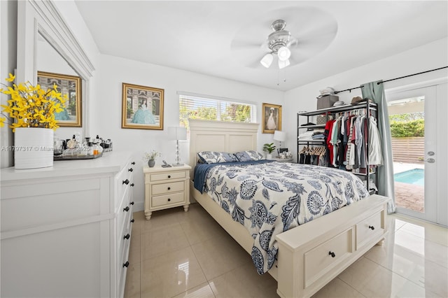 bedroom featuring access to outside, multiple windows, light tile patterned flooring, and a ceiling fan