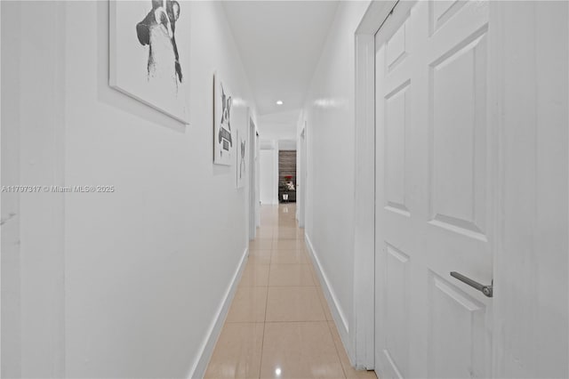 hall featuring light tile patterned floors, baseboards, and recessed lighting