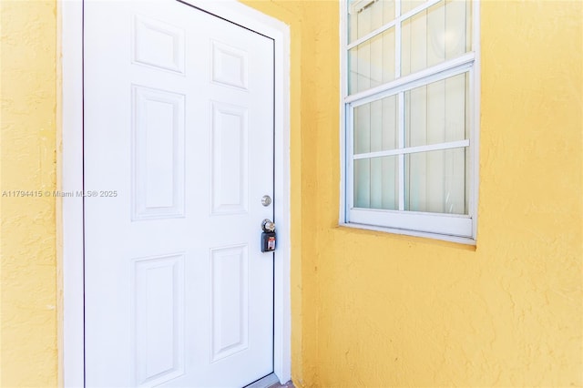 doorway to property featuring stucco siding