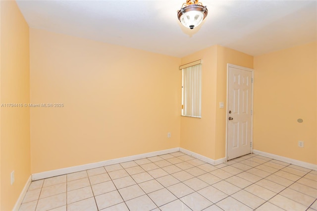 spare room with light tile patterned floors and baseboards