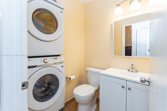 half bathroom with tile patterned flooring, toilet, stacked washer and dryer, and vanity