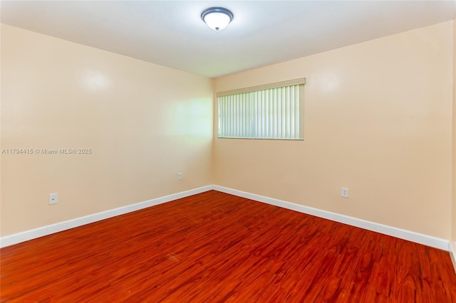 empty room with baseboards and wood finished floors