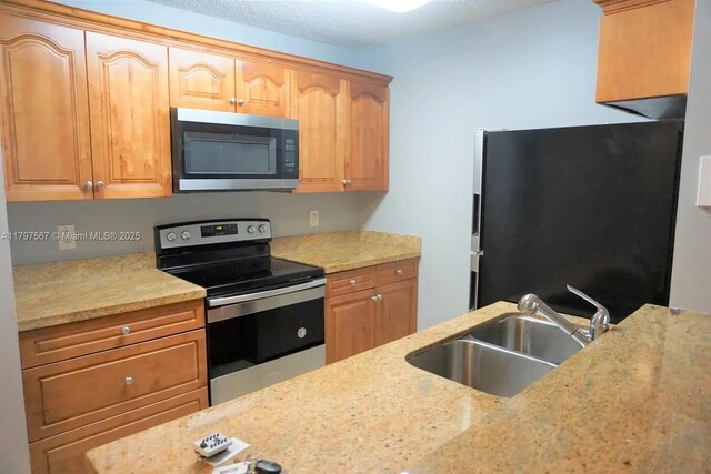 1722 W Meadows Cir W Unit 1722, Boynton Beach, FL 33436 - kitchen featuring a sink, stainless steel appliances, and light stone counters