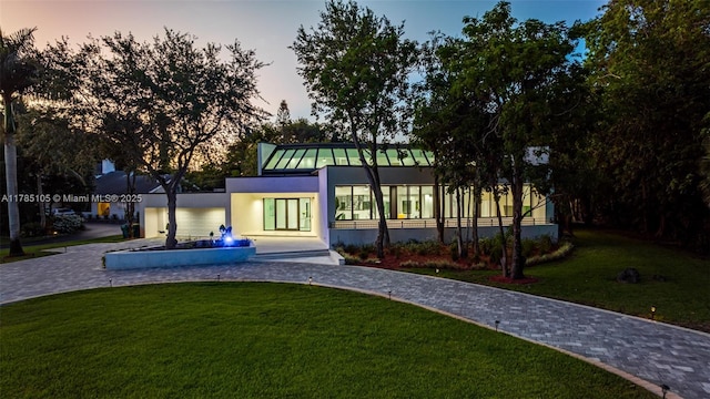 view of home's community featuring a lawn and curved driveway