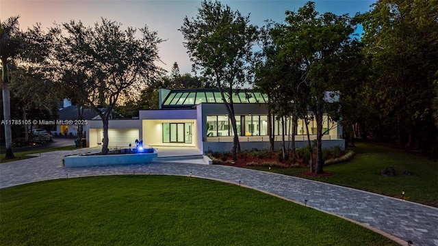 view of home's community with curved driveway and a lawn