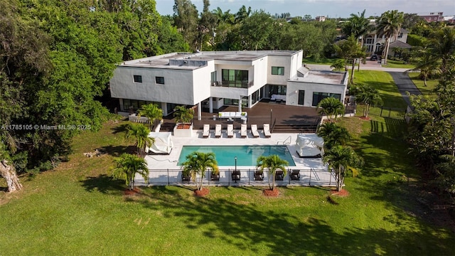 rear view of house featuring a lawn, a balcony, a fenced in pool, a patio, and a fenced backyard