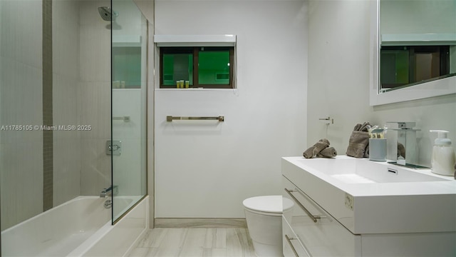 full bathroom with toilet, marble finish floor, bathing tub / shower combination, and vanity