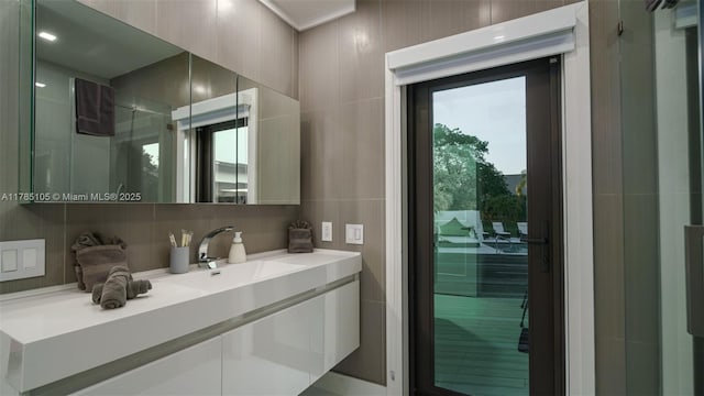 bathroom featuring backsplash, tile walls, walk in shower, and vanity