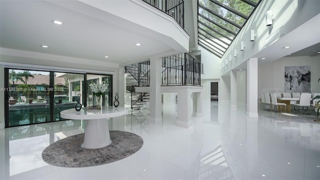 foyer entrance featuring stairway, tile patterned flooring, a wealth of natural light, and a high ceiling