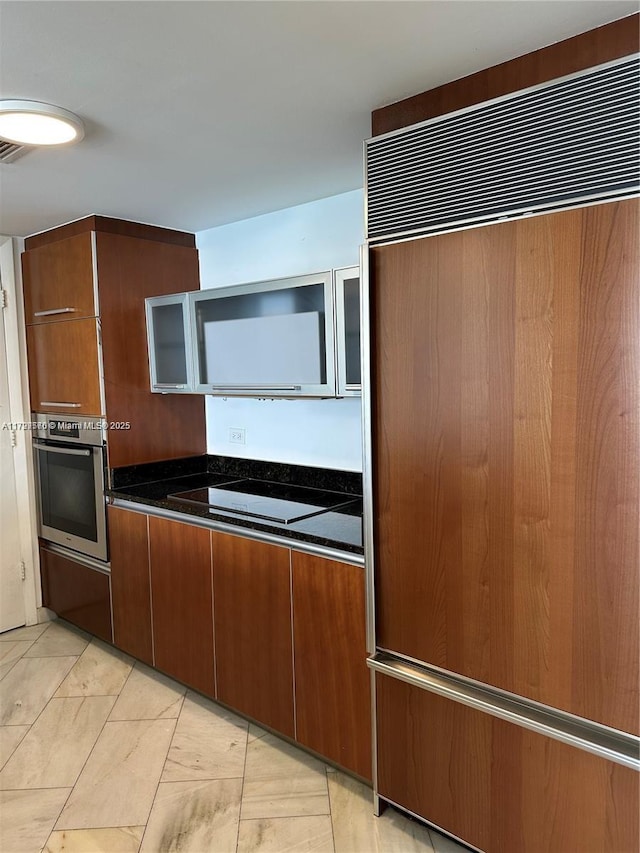 17201 Collins Ave Unit 1605, Sunny Isles Beach, FL 33160 - kitchen with oven, black electric stovetop, paneled built in fridge, and brown cabinetry